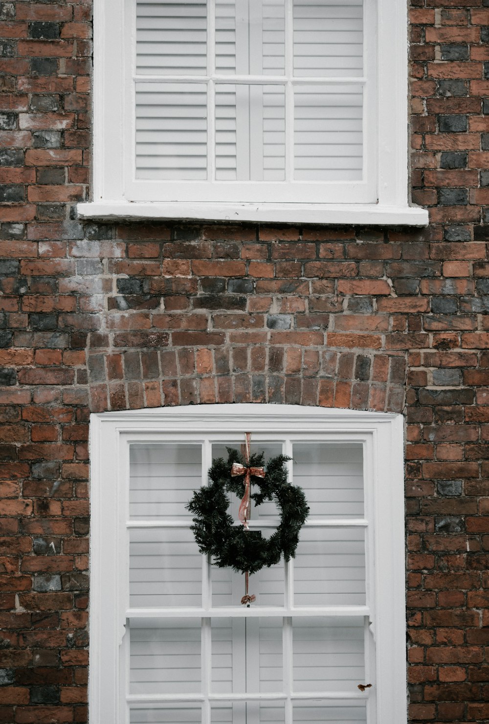green wreath hanging on white window