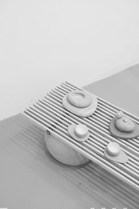 Close-up of hands arranging natural elements on a charcoal grey surface, evoking tactile connection.