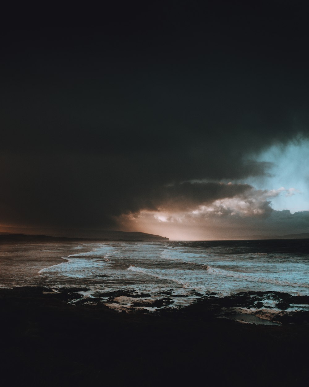 body of water under dark clouds