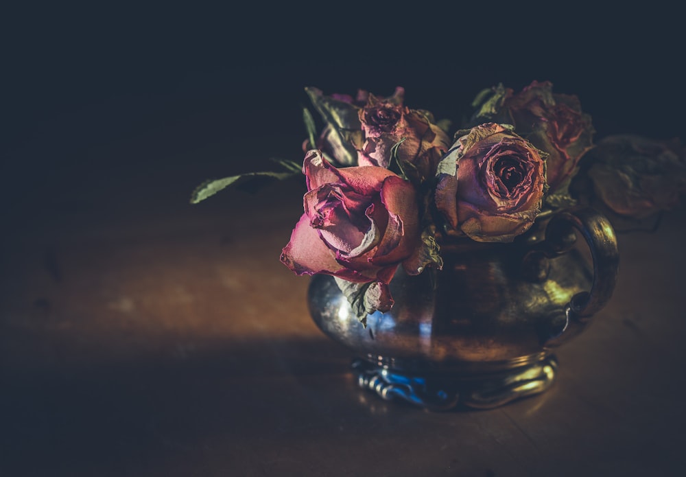 withered roses in clear glass vase