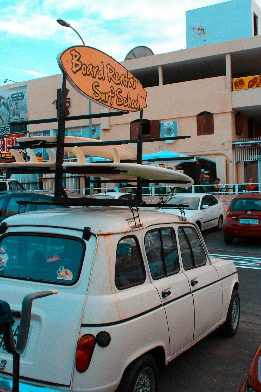 Vehículo blanco estacionado cerca de un edificio de hormigón beige