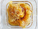 Freshly harvested honeycomb laid out on a wooden table in a mountain cabin.