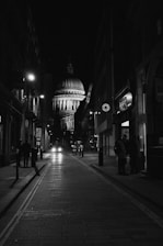 grayscale photo of empty road between buildings