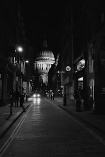 grayscale photo of empty road between buildings