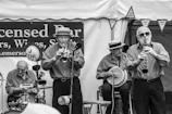 Vintage-style photo of the band posing with their instruments outdoors.
