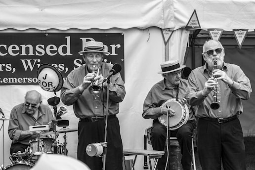 grayscale photo of group of people playing on stage