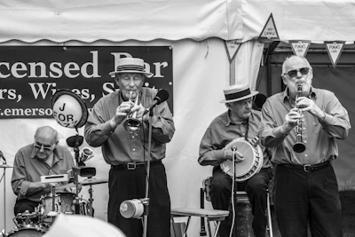 Vintage-style photo of the band posing with their instruments outdoors.