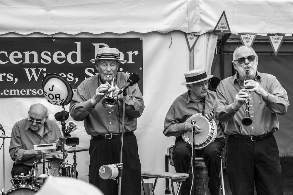 grayscale photo of group of people playing on stage