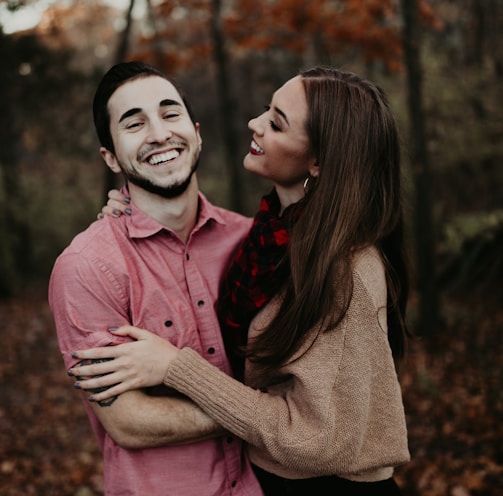 woman hugging man selective focus photography