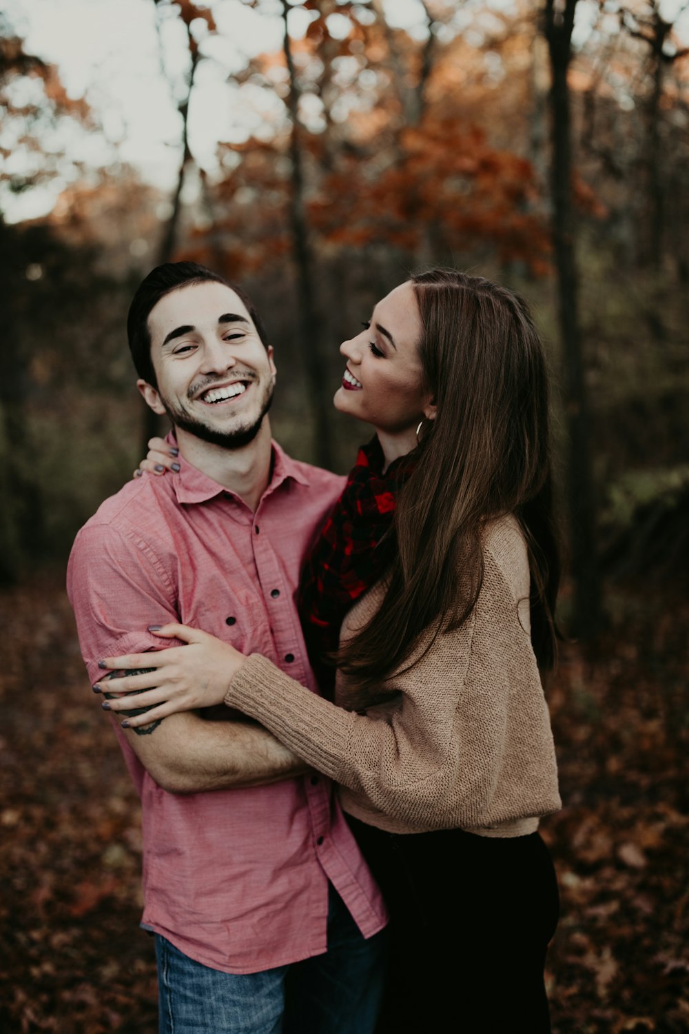 woman hugging man selective focus photography