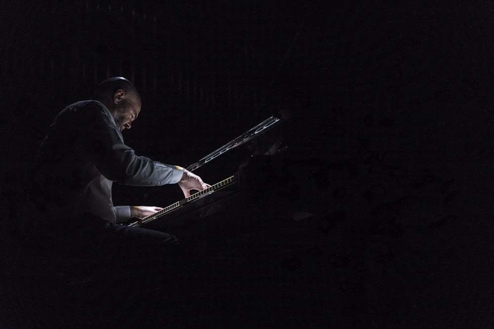 Ein Mann, der im Dunkeln ein Keyboard spielt