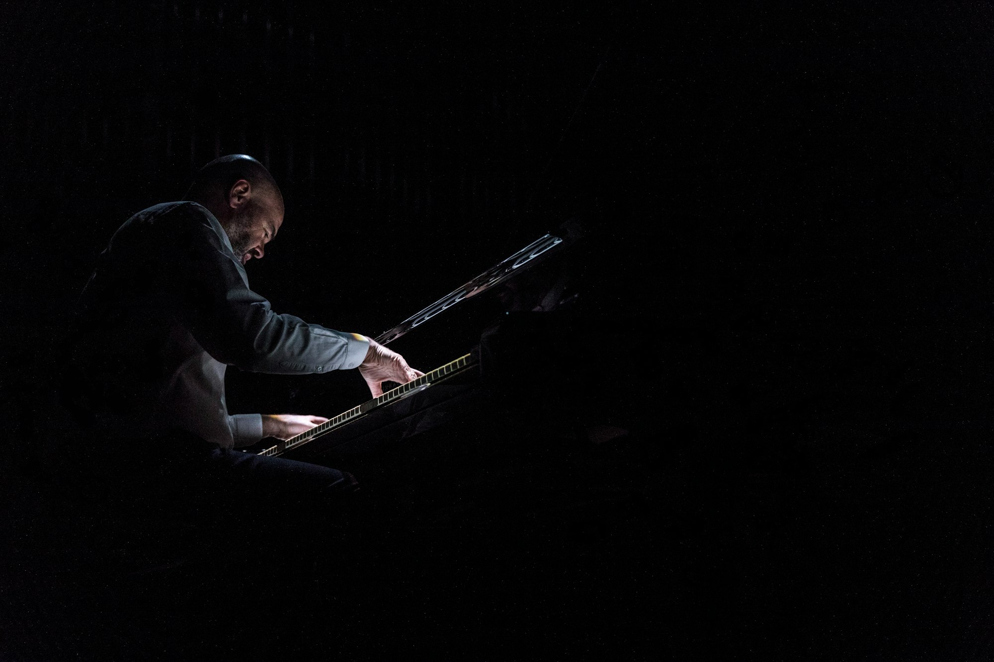 a man playing a keyboard in the dark