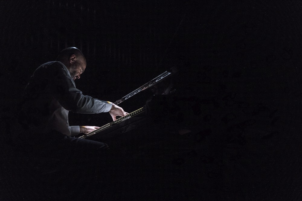 Un hombre tocando un teclado en la oscuridad