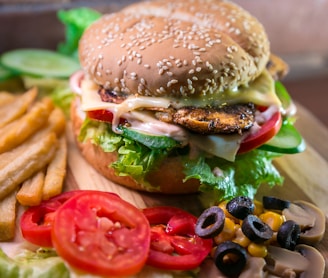 hamburger with vegetables and meat beside French fries