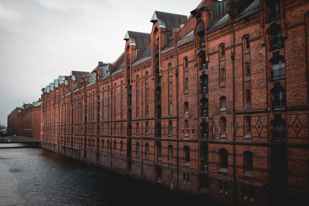 photo of brown building beside body of water