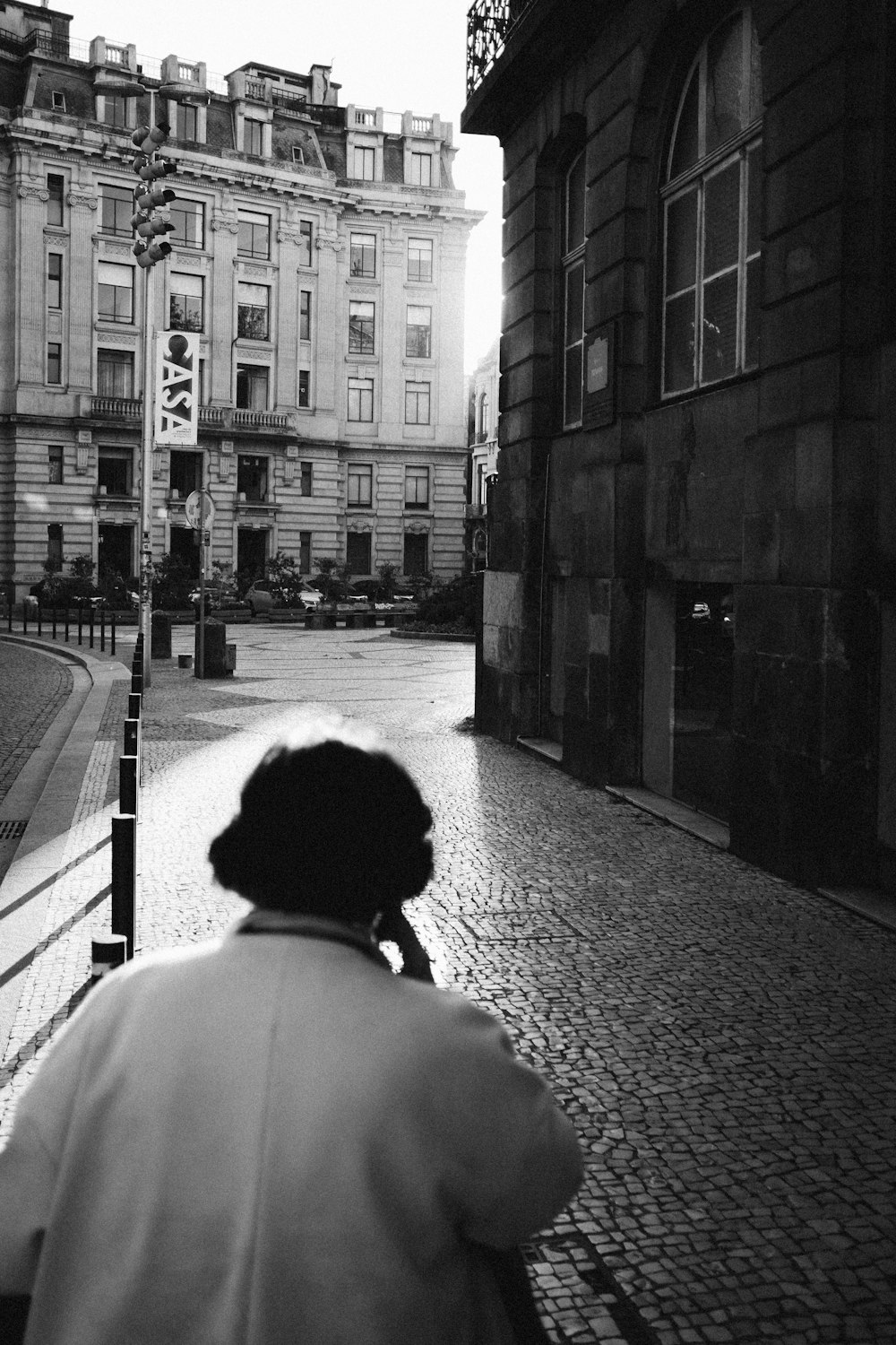 grayscale photo of person passing through building