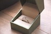 silver-colored ring with gemstone in a box