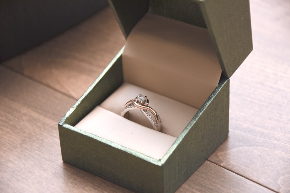 silver-colored ring with gemstone in a box