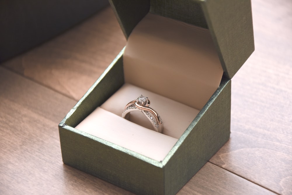箱に入った宝石をあしらった銀色の指輪