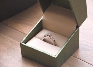 silver-colored ring with gemstone in a box