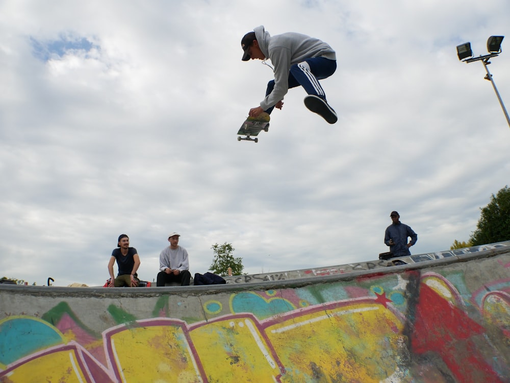 Mann in der Luft, der tagsüber über der Skateboard-Rampe Skateboard spielt
