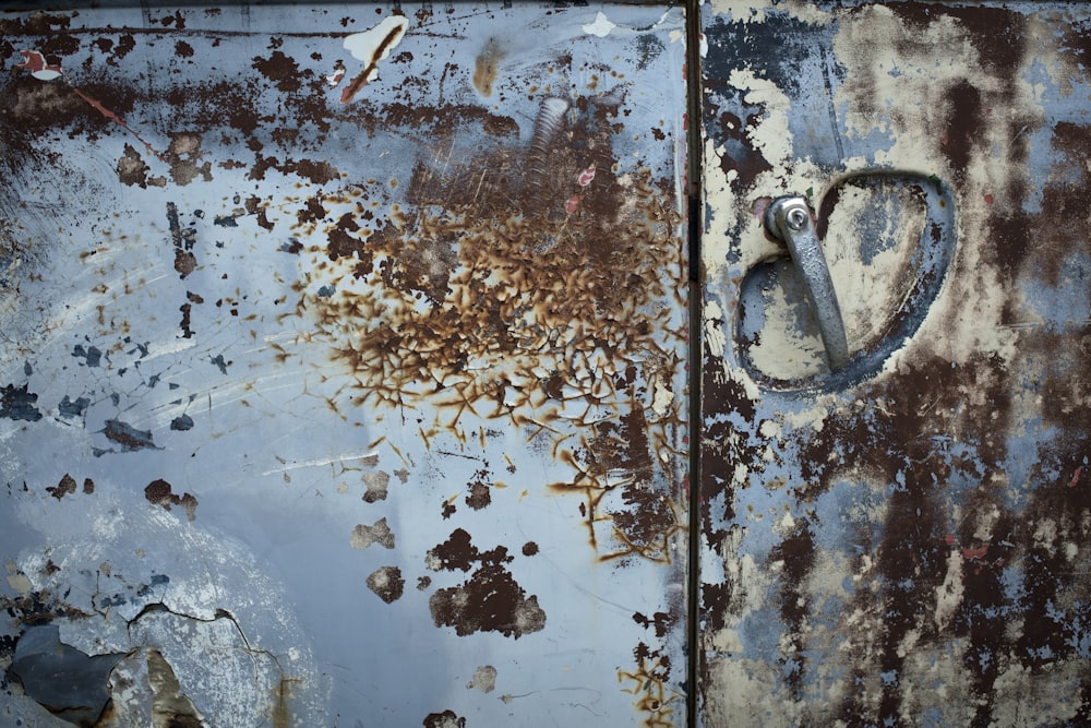 a rusted metal door with a heart shaped handle
