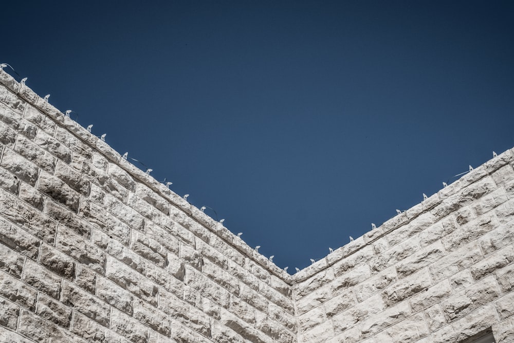 low angle photography of gray concrete wall at daytime