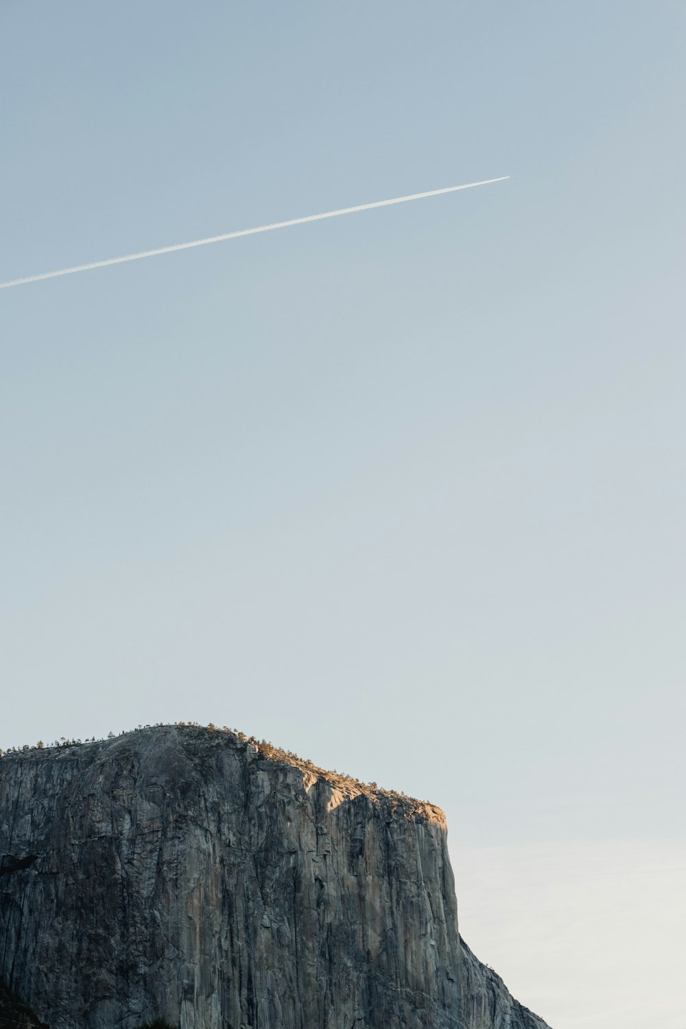 cliff under cloudy sky during daytime