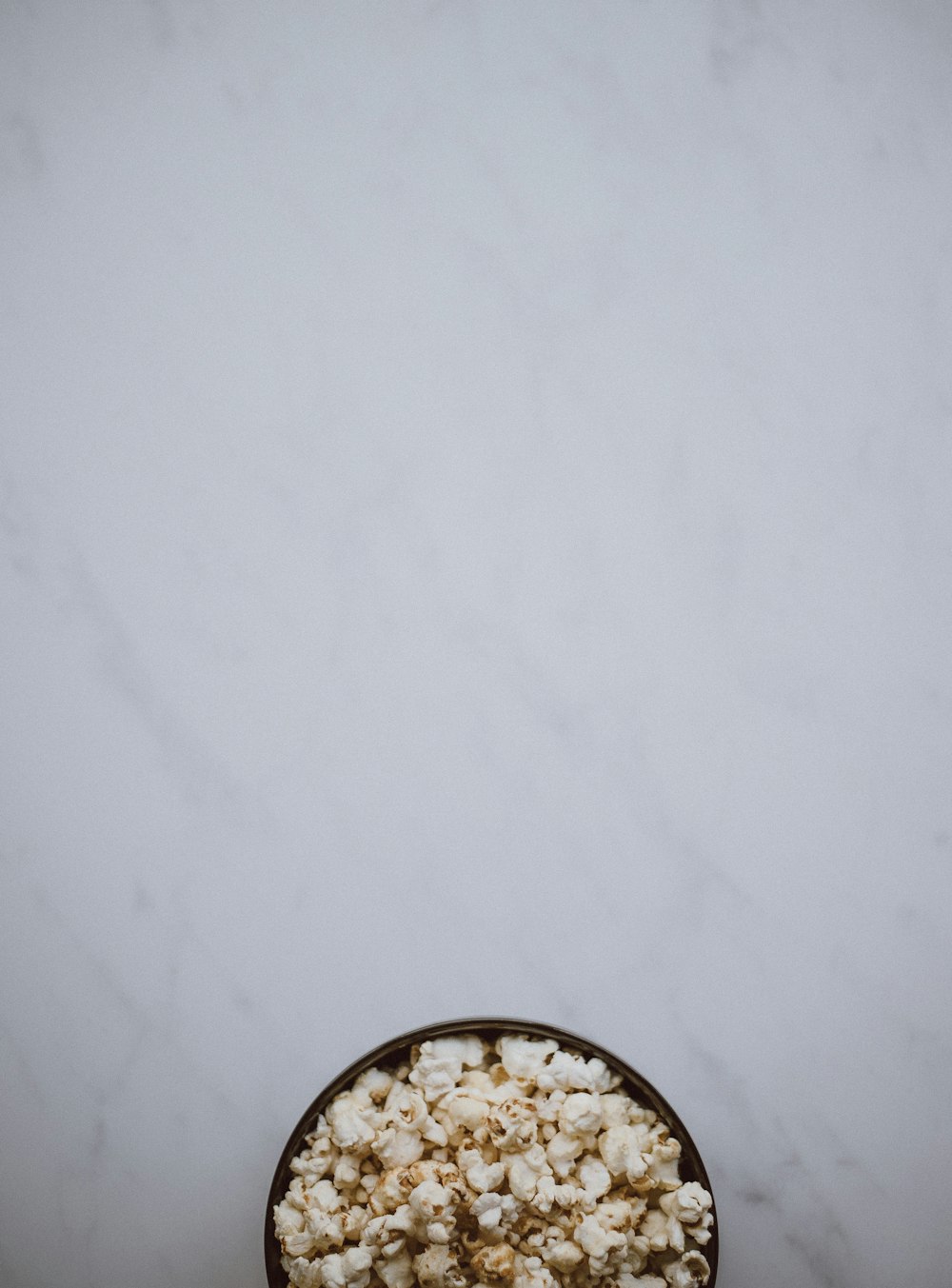 bowl of popcorn on white surface