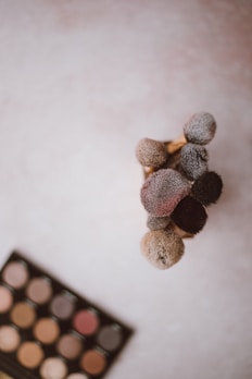 Elegant makeup brushes arranged neatly beside vibrant eyeshadow palettes with shimmering colors.