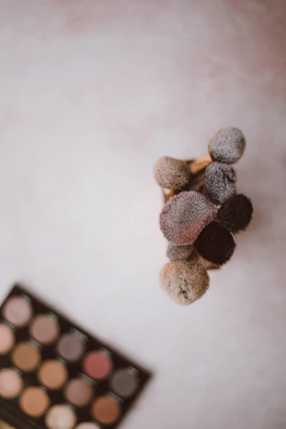 Step-by-step makeup brushes arranged neatly beside a vibrant eyeshadow palette.