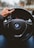person holding BMW vehicle steering wheel