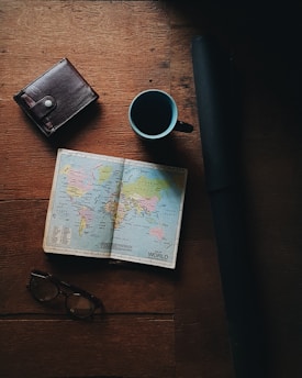 world map beside blue and black ceramic mug