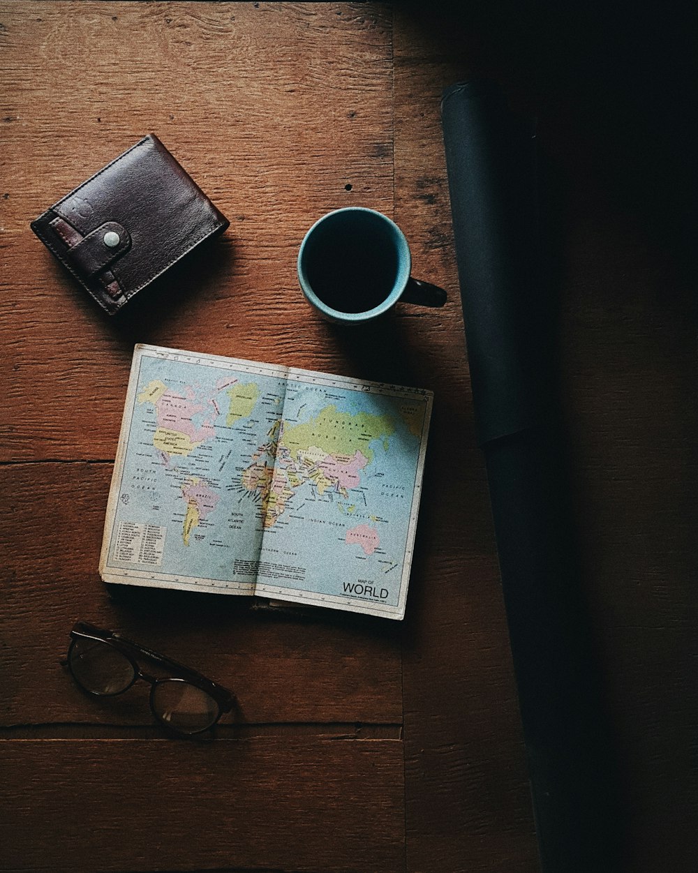 world map beside blue and black ceramic mug