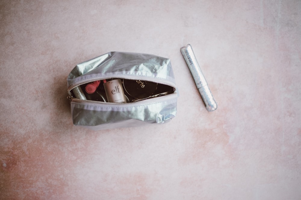 gray leather pouch on brown surface