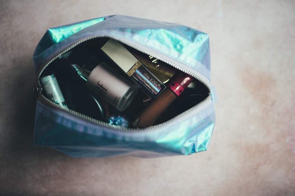 assorted cosmetic products on blue bag