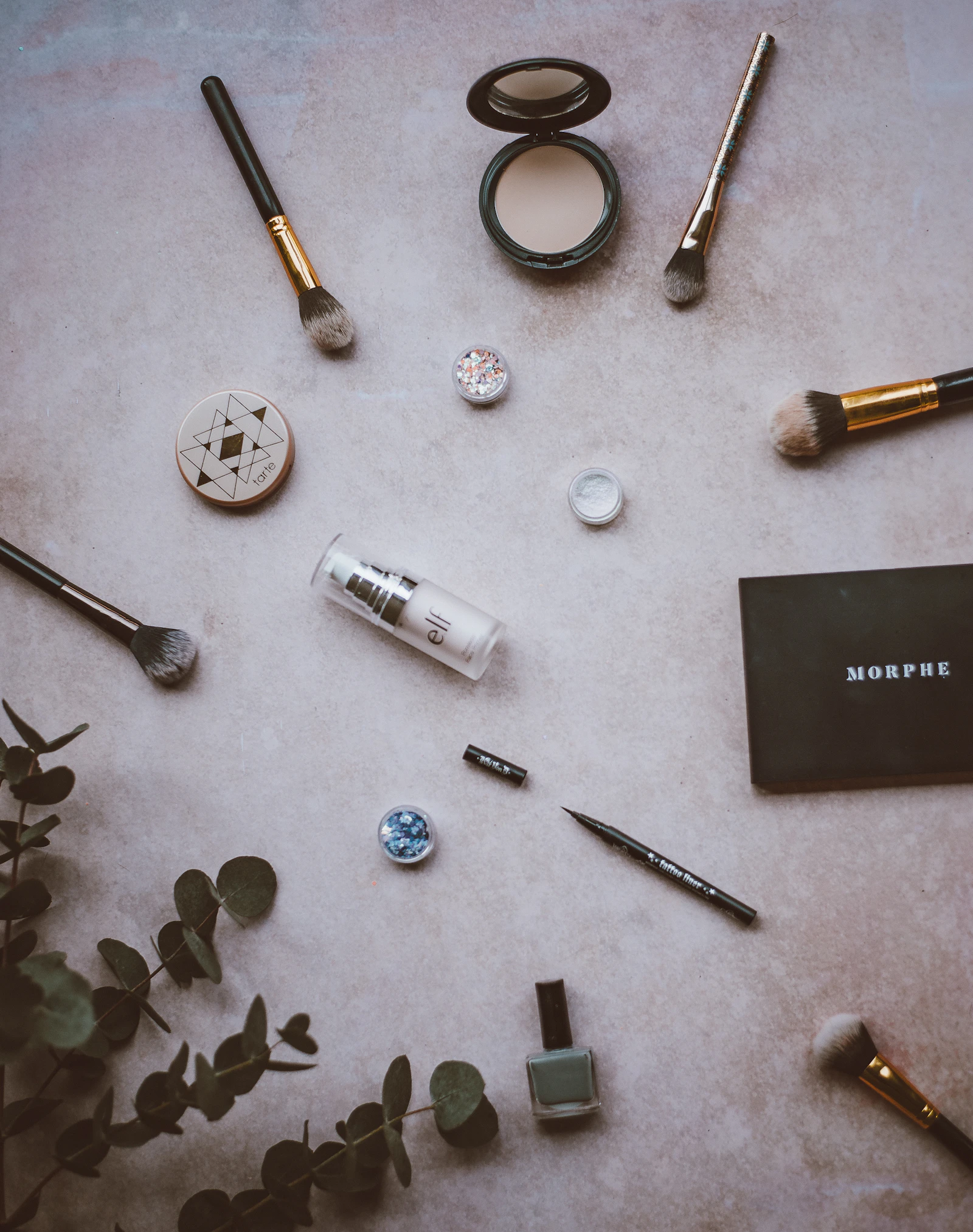 Complexion and skincare products displayed in a neutral beauty setting