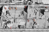 selective color photo of man on top of gray building