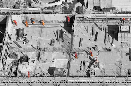 selective color photo of man on top of gray building