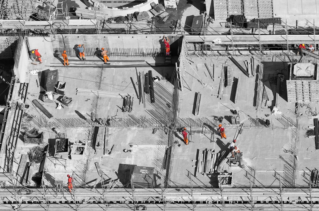 selective color photo of man on top of gray building, Men at work 765