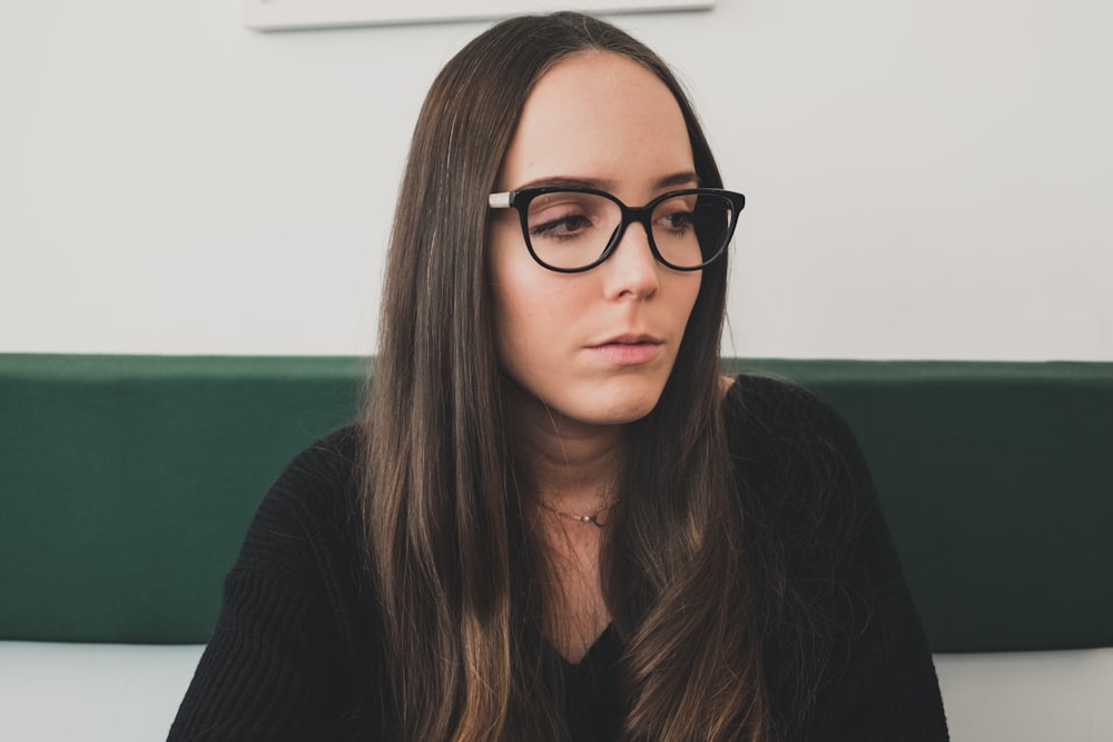 brunette haired woman in black shirt wearing eyeglasses