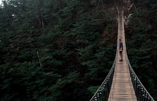 man standing on the middle of the bridge outdoor in Torres del Paine National Park Chile