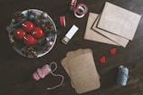 Hands crafting a mini wreath album with colorful holiday decorations.