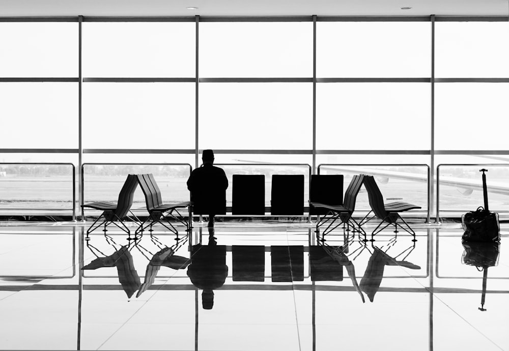 man sitting on gang chair during daytime