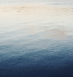 Sound waves gently rippling over a minimalist, light-toned background with soft glowing accents.