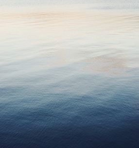 Sound waves gently rippling over a minimalist, light-toned background with soft glowing accents.