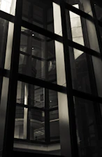 Close-up of a sleek glass curtain wall reflecting natural light in a modern building.