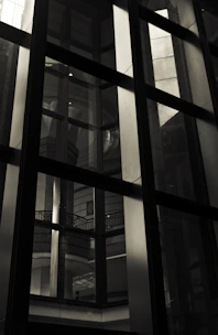 Close-up of a sleek glass curtain wall reflecting natural light in a modern building.
