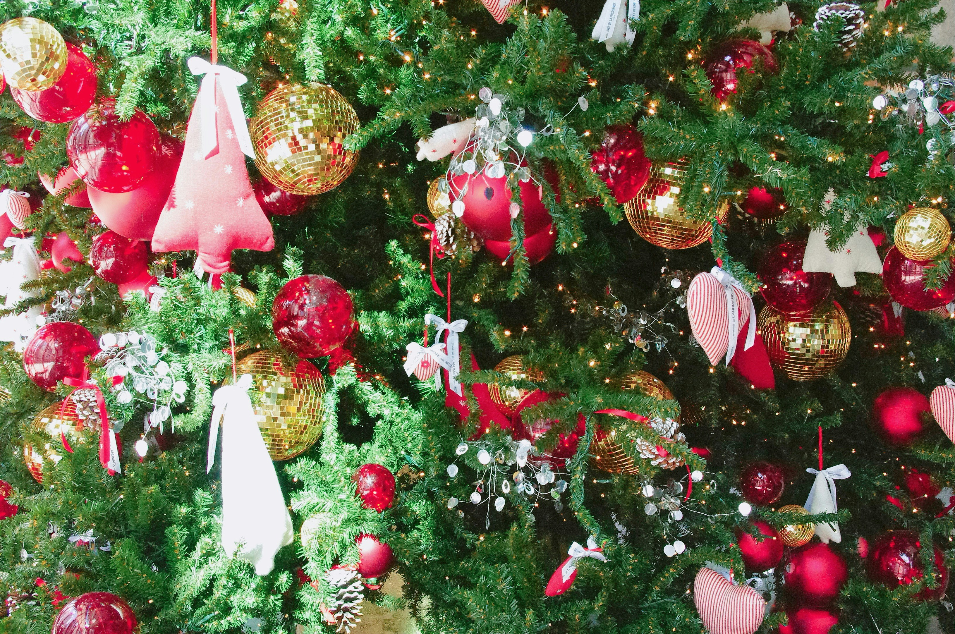 gold and red baubles on christmas tree bells teams background