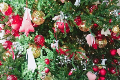 gold and red baubles on christmas tree bells teams background